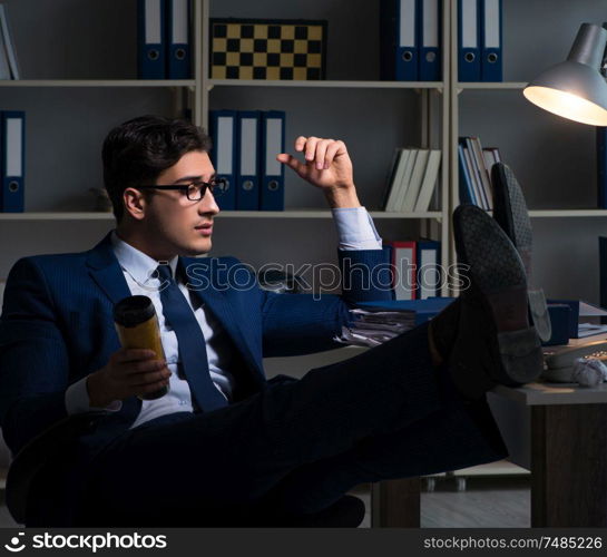 The employee working late and drinking strong coffee to stay awake. Employee working late and drinking strong coffee to stay awake