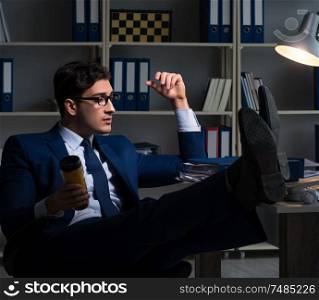 The employee working late and drinking strong coffee to stay awake. Employee working late and drinking strong coffee to stay awake