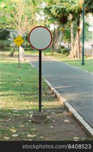 The empty white circular sign on the roadside in the public park.