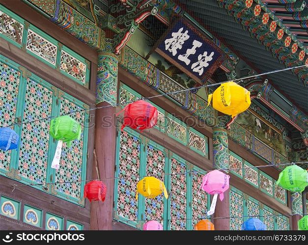 The entrance to the Bogeunsa Buddhist Temple in Seoul, South Korea is painted with bright colors and festooned with colored paper lanterns.