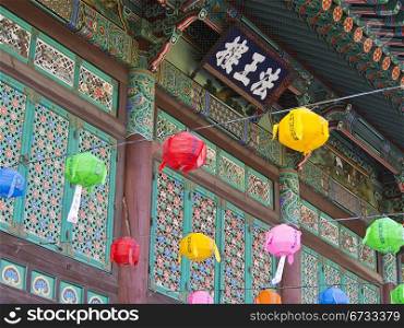 The entrance to the Bogeunsa Buddhist Temple in Seoul, South Korea is painted with bright colors and festooned with colored paper lanterns.