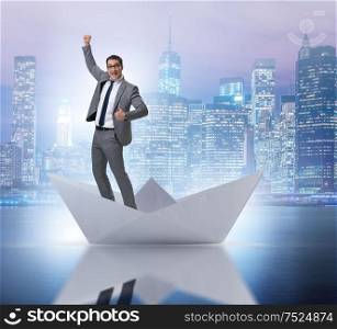 The excited businessman riding paper ship boat. Excited businessman riding paper ship boat