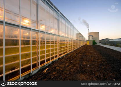 The exterior glass fascade of a huge glasshouse with heating system and generator