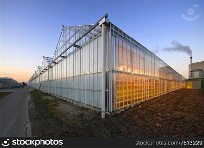 The exterior glass fascade of a huge glasshouse with heating system and generator