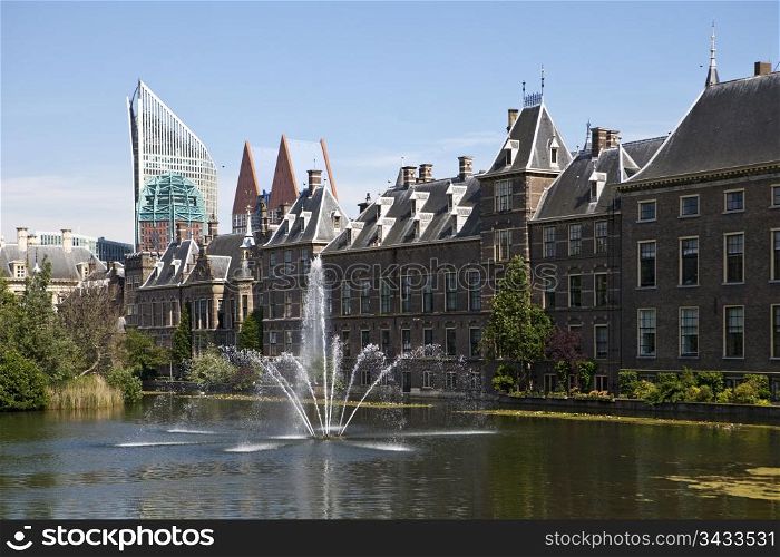 The exterior of the Binnenhof, or Netherlands Parliament building in The Hague, as viewed over the Hofvijver lake and fountain.