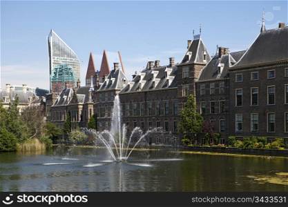 The exterior of the Binnenhof, or Netherlands Parliament building in The Hague, as viewed over the Hofvijver lake and fountain.
