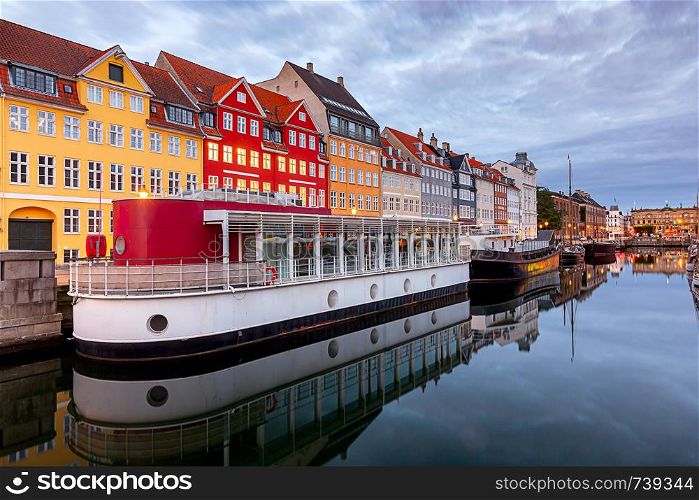The facades of the famous colorful houses along the Nyhavn canal. Copenhagen. Denmark.. Copenhagen. Nyhavn Canal, colorful houses and city embankment at sunrise.