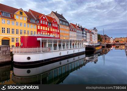The facades of the famous colorful houses along the Nyhavn canal. Copenhagen. Denmark.. Copenhagen. Nyhavn Canal, colorful houses and city embankment at sunrise.
