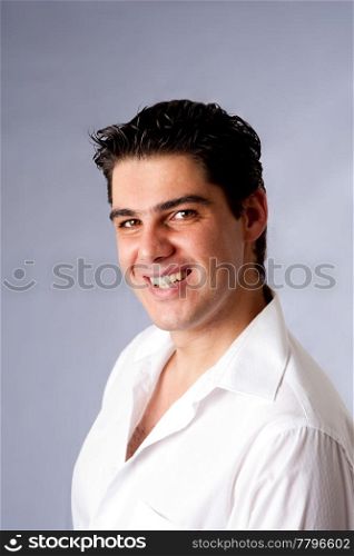 The face of a beautiful handsome Caucasian man with a big smile dressed in white, isolated.