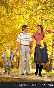 The family with two children walks on autumn park