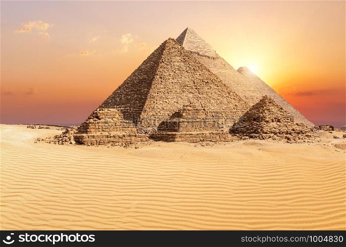 The famous Giza Pyramids in the desert at sunset, Egypt.. The famous Giza Pyramids in the desert at sunset, Egypt