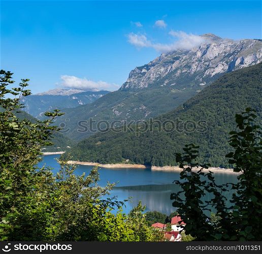 The famous Piva river canyon with its fantastic reservoir Piva Lake (Pivsko Jezero) and Pluzine town summer view in Montenegro. Nature travel background.