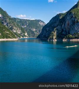 The famous Piva river canyon with its fantastic reservoir Piva Lake (Pivsko Jezero) summer view and shadow of bridge on water surface, Montenegro. Nature travel background.