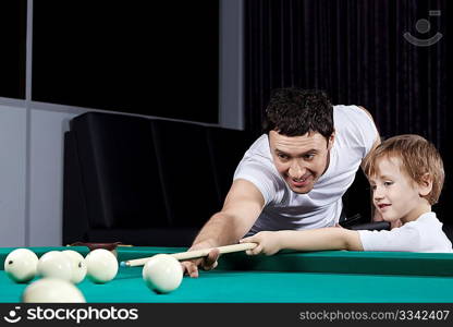 The father and the son play billiards