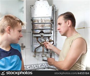 The father and the son repair a gas water heater together