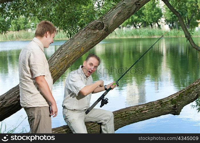 The father with the son on fishing. Rejoice to a biting