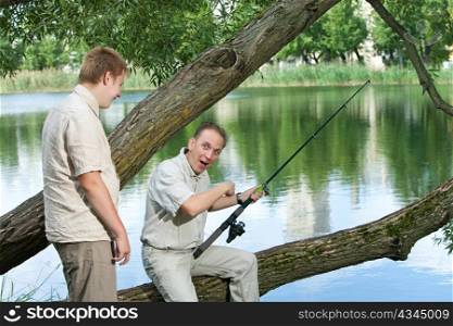 The father with the son on fishing. Rejoice to a biting