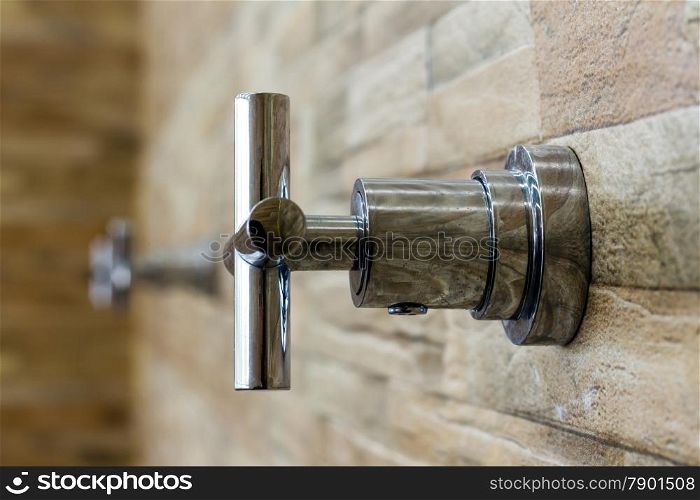 The faucet on the brick wall background (select focus)
