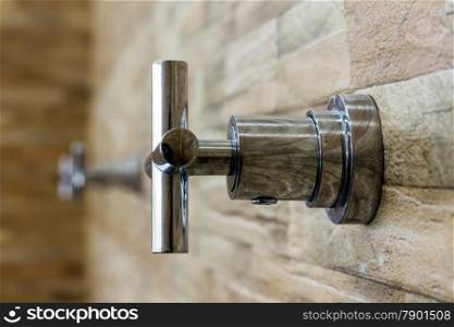 The faucet on the brick wall background (select focus)