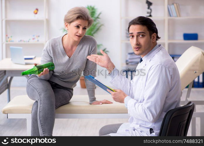 The female alcoholic visiting young male doctor. Female alcoholic visiting young male doctor