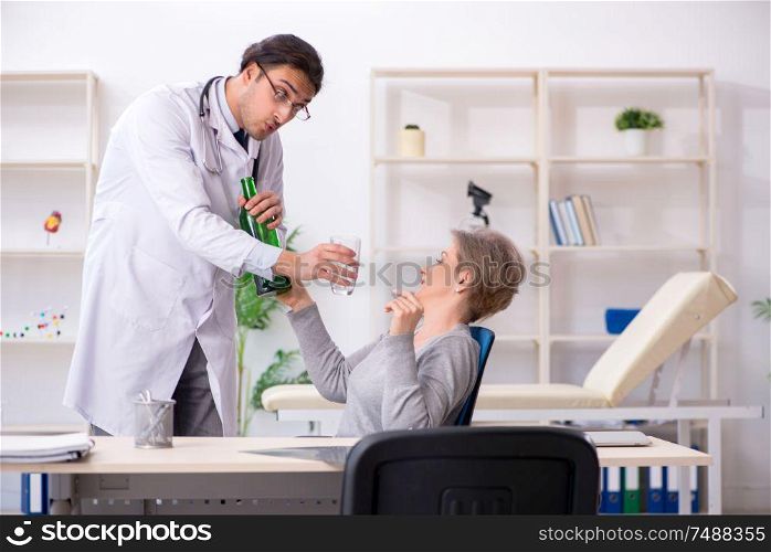 The female alcoholic visiting young male doctor . Female alcoholic visiting young male doctor