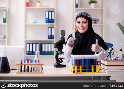 The female chemist in hijab working in the lab. Female chemist in hijab working in the lab