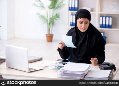 The female employee bookkeeper in hijab working in the office . Female employee bookkeeper in hijab working in the office 