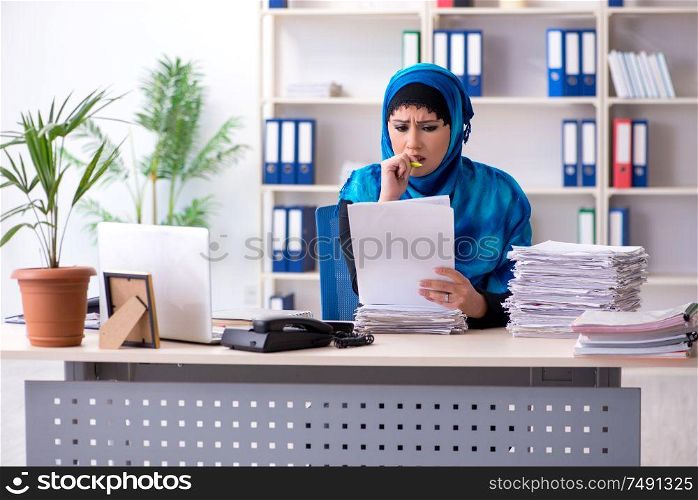 The female employee in hijab working in the office. Female employee in hijab working in the office