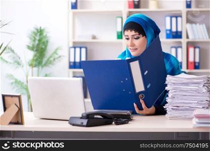 The female employee in hijab working in the office. Female employee in hijab working in the office