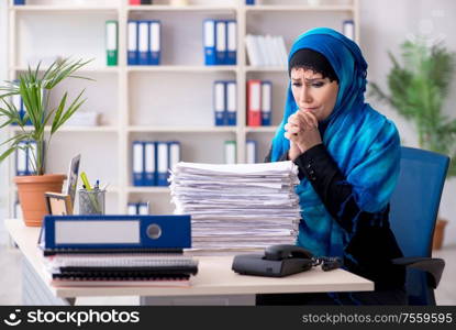 The female employee in hijab working in the office. Female employee in hijab working in the office