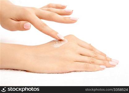 The female hand puts a cream on other hand, isolated