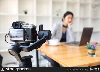 The filmmaker is recording and broadcasting business woman working at office on stabilizer camcorders. Professional Video Recording.