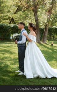 the first meeting of the bride and groom in wedding outfits in the park