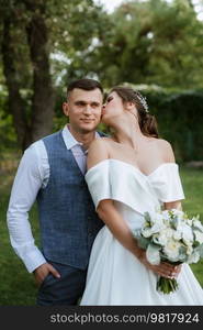 the first meeting of the bride and groom in wedding outfits in the park