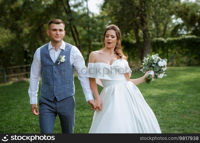 the first meeting of the bride and groom in wedding outfits in the park