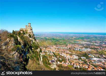 The first tower of San Marino and Borgo Maggiore at the foot of mount Titano, San Marino - Panoramic landscape with space for your own text