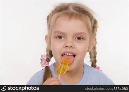 the five-year old girl enthusiastically eats candy
