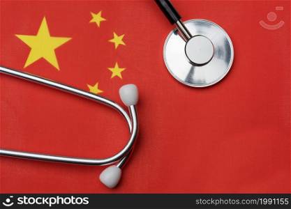 The flag of China and a stethoscope. The concept of medicine. Stethoscope on the flag in the background.. The flag of China and a stethoscope. The concept of medicine.