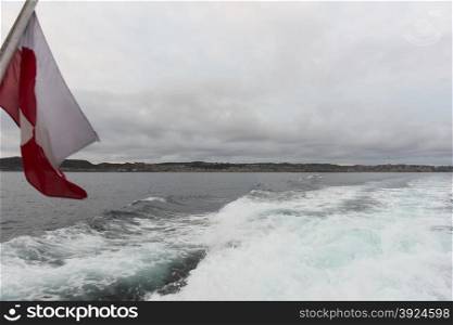 The flag of Greenland on a ship. The flag of greenland on a ship cruising in the waters around Aasiaat