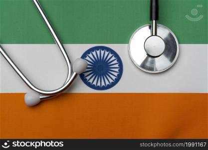 The flag of India and a stethoscope. The concept of medicine. Stethoscope on the flag in the background.. The flag of India and a stethoscope. The concept of medicine.