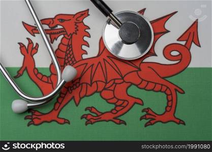 The flag of Wales and a stethoscope. The concept of medicine. Stethoscope on the flag as a background.. The flag of Wales and a stethoscope. The concept of medicine.