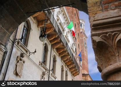 The flags of Italy and Europe in the facade of the Palazzo del Capitano, Piazza Dante, Verona, Italy