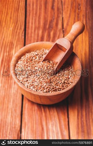 The flax seeds in a wooden bowl close up. flax seeds