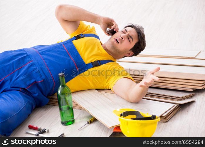 The floor repairman drinking alcohol during break. Floor repairman drinking alcohol during break