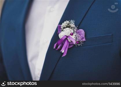 The floral decoration on the mans chest.. A corsage of small flowers on the chest of the groom 9374.