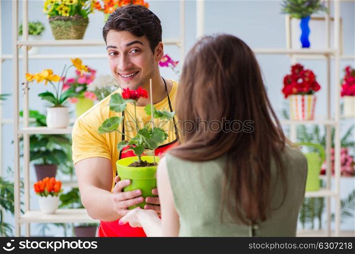 The florist selling flowers in a flower shop. Florist selling flowers in a flower shop