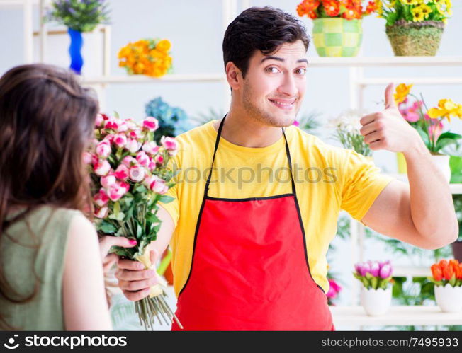 The florist selling flowers in a flower shop. Florist selling flowers in a flower shop