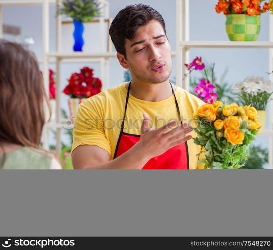 The florist selling flowers in a flower shop. Florist selling flowers in a flower shop