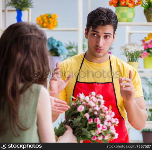 The florist selling flowers in a flower shop. Florist selling flowers in a flower shop