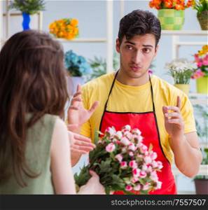 The florist selling flowers in a flower shop. Florist selling flowers in a flower shop